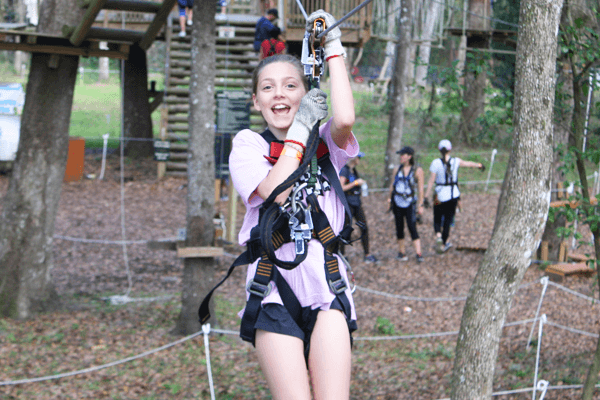 Young Girl Ziplines Toward Camera