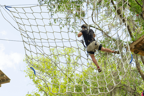 Man Climbs Net on Black Storm Course